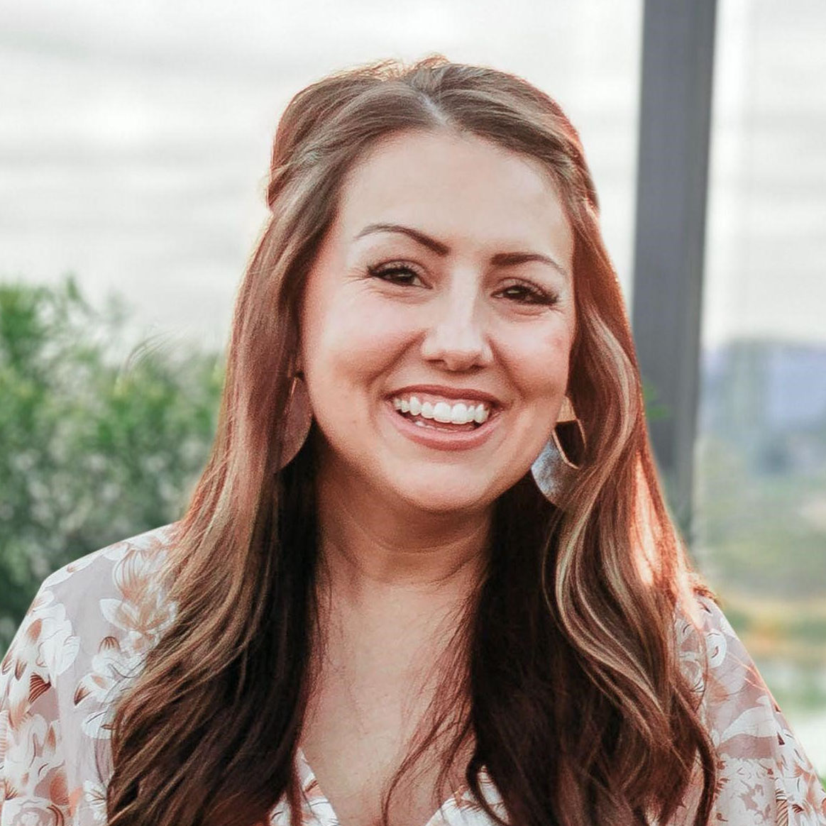 Kathryn Little, wearing a floral blouse, smiling.